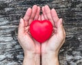 WomenÃ¢â¬â¢s heart health care, medical concept with healthy red love heart on aging hand support Royalty Free Stock Photo